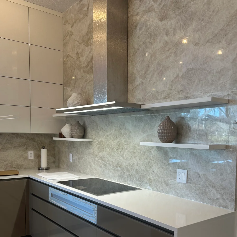 Modern kitchen remodel featuring custom white cabinets, elegant gray marble walls, and a sleek built-in stovetop. High-quality craftsmanship by Power Pro Maintenance & Repairs in Jacksonville, FL.